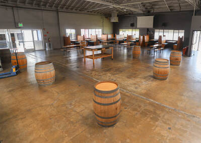 The southeast section of the Barrel Room set up with tables, barrel-top tables, and banquettes